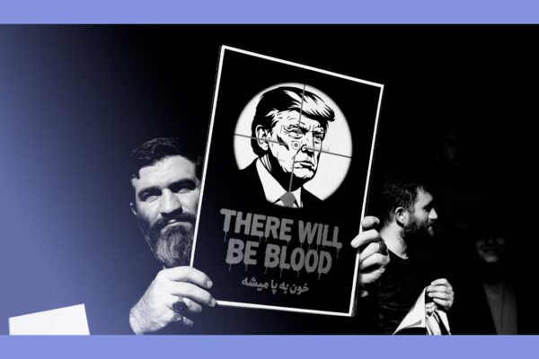 A man holds a placard with the face of Donald Trump on, reading 'there will be blood'.